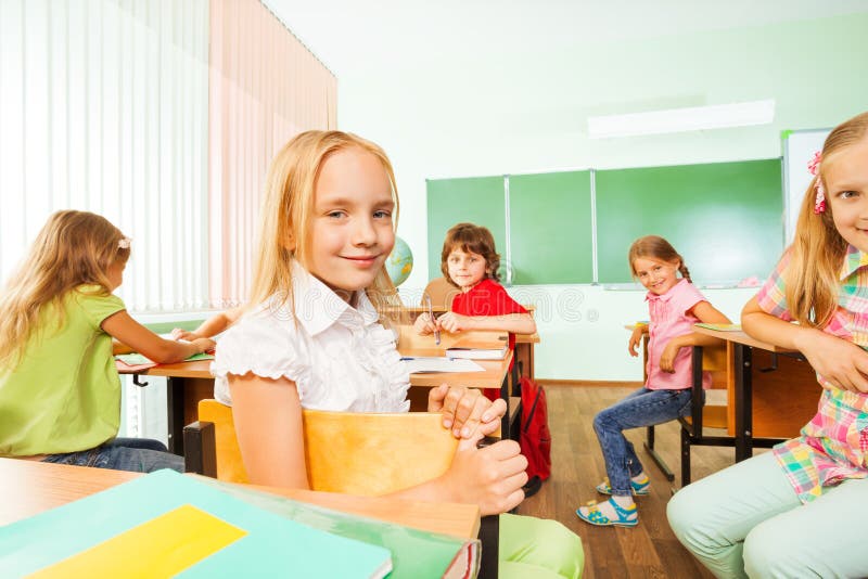 Positive pupils turned back of the class sitting stock photography