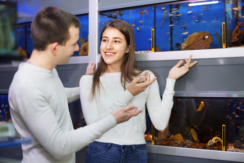 Positive smiling customers selecting tropical fish stock photos Positive smiling customers selecting tropical fish stock photos
