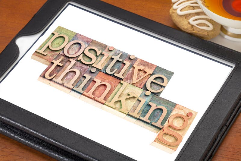 Positive thinking typography - isolated text in letterpress wood type blocks on a digital tablet with a cup of tea. Positive thinking typography - isolated text in letterpress wood type blocks on a digital tablet with a cup of tea