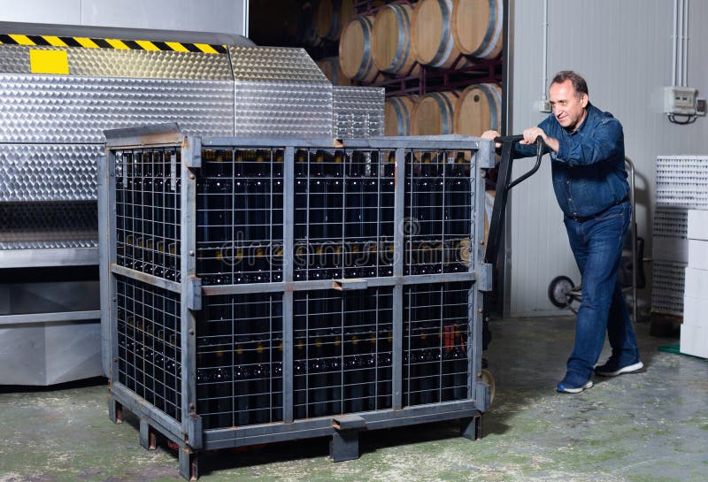 Worker of Winery Costs Near Container with Bottles Stock Image Image