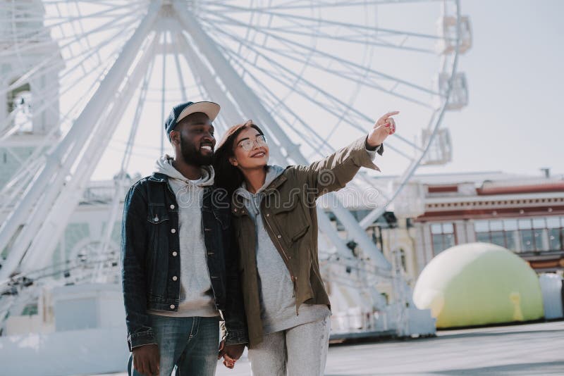 https://thumbs.dreamstime.com/b/positive-young-international-couple-having-walk-their-native-city-standing-near-ferris-wheel-cheerful-young-129379879.jpg