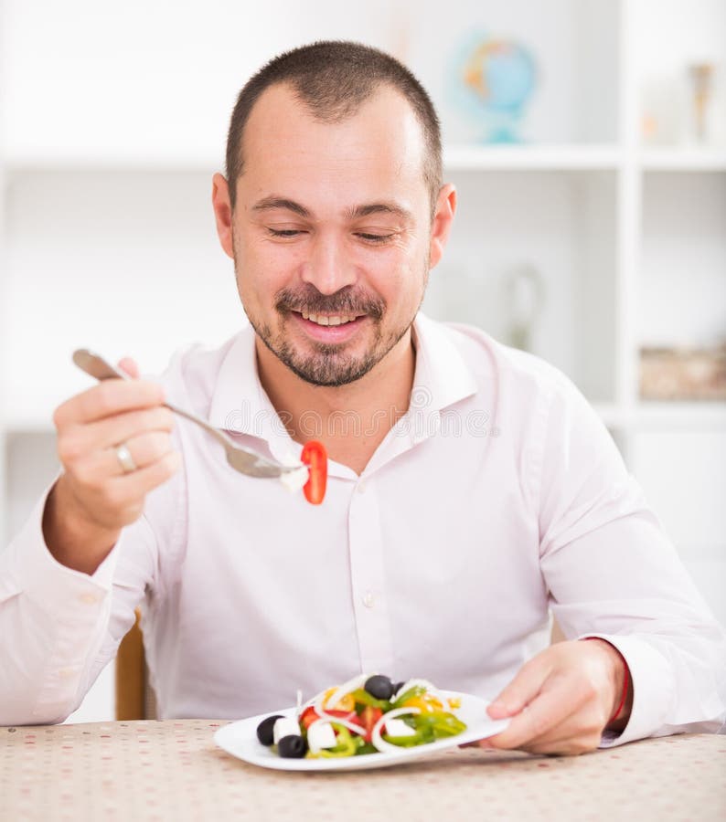 Positive Young Man Eating Greek Salad Stock Image - Image of people