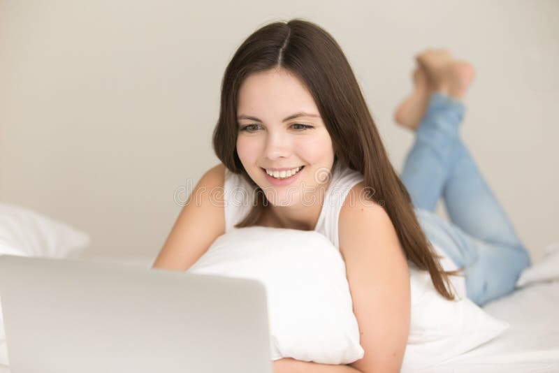 Positives jugendlich Mädchen, das online im Bett zu Hause kauft lizenzfreie stockfotos Positives jugendlich Mädchen, das online im Bett zu Hause kauft lizenzfreie stockfotos