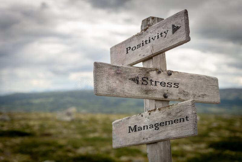 Positivity, stress and management text on wooden road sign outdoors in nature