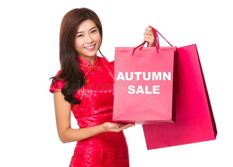 Posse chinesa da mulher com saco de papel vermelho e mostrar a venda do outono imagem de stock Posse chinesa da mulher com saco de papel vermelho e mostrar a venda do outono imagem de stock