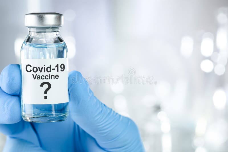 Possible cure with a hand in blue medical gloves holding Coronavirus, Covid 19 virus, vaccine vial