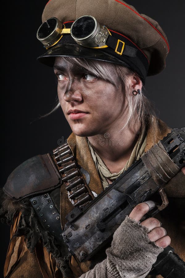 Nuclear post apocalypse life after doomsday concept. Grimy female survivor with homemade weapons. Studio portrait on black background. Nuclear post apocalypse life after doomsday concept. Grimy female survivor with homemade weapons. Studio portrait on black background