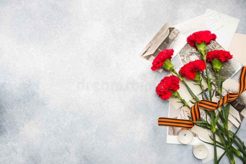 Postcard may 9 - red carnations Ribbon George Old photos on a concrete background. Symbol of victory in the great Patriotic war stock photography Postcard may 9 - red carnations Ribbon George Old photos on a concrete background. Symbol of victory in the great Patriotic war stock photography