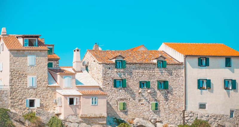 POSTIRA, CROACIA - 18 DE JULIO DE 2017: Porciones de casas viejas hermosas empleadas roca en el puerto de una pequeña ciudad Post imagenes de archivo POSTIRA, CROACIA - 18 DE JULIO DE 2017: Porciones de casas viejas hermosas empleadas roca en el puerto de una pequeña ciudad Post imagenes de archivo