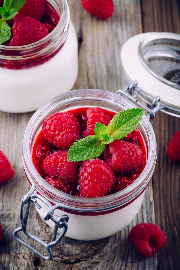 Postre con el queso cremoso, la salsa de la frambuesa, las bayas frescas y la menta imagen de archivo Postre con el queso cremoso, la salsa de la frambuesa, las bayas frescas y la menta imagen de archivo