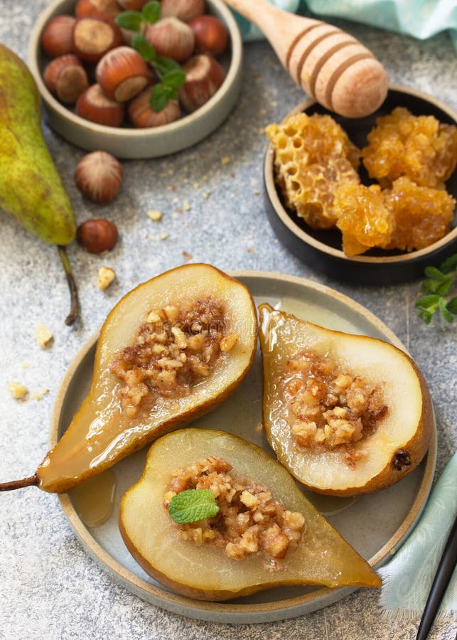 Postre saludable. peras cocidas con miel de avellanas y granola en pizarra fotografía de archivo