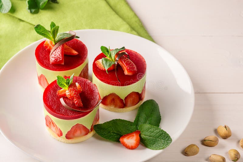 Postre - torta dulce con la fresa en una placa con la menta fresca y los pistachos fotografía de archivo libre de regalías Postre - torta dulce con la fresa en una placa con la menta fresca y los pistachos fotografía de archivo libre de regalías