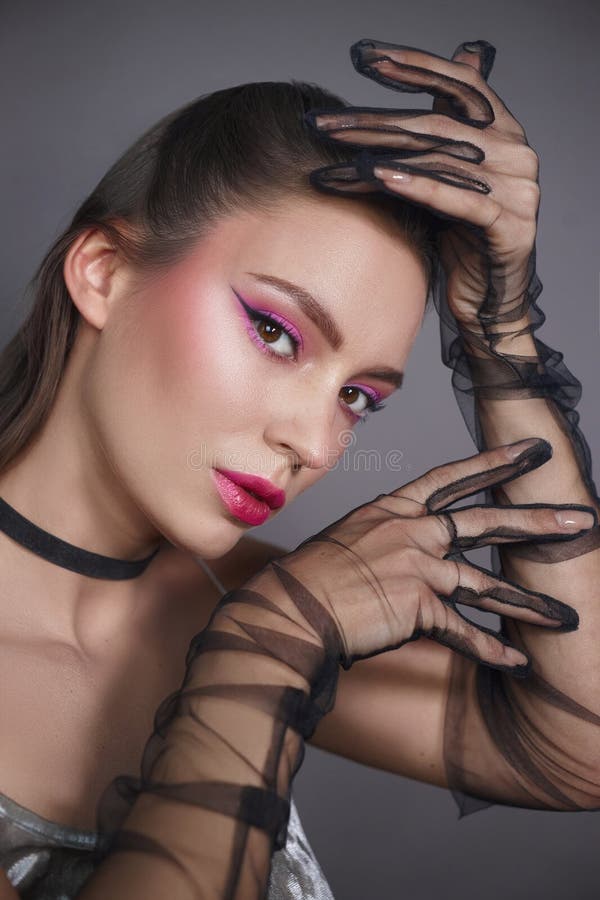 Posture modello con artefice che presentano caratteristiche di trucco stridore come eyeliner grassato e labbra vibranti integrate fotografie stock