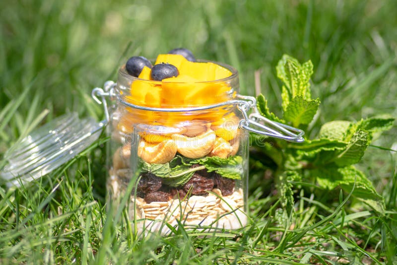 Posé des fruits et des écrous colorés dans un pot Concept sain images stock Posé des fruits et des écrous colorés dans un pot Concept sain images stock