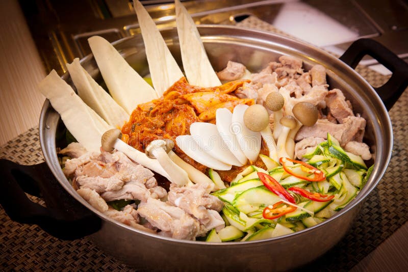 Pot chaud coréen de porc avec le champignon, le chi de Kim et le concombre image stock Pot chaud coréen de porc avec le champignon, le chi de Kim et le concombre image stock