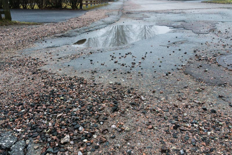 Pot holes with water in road stock images