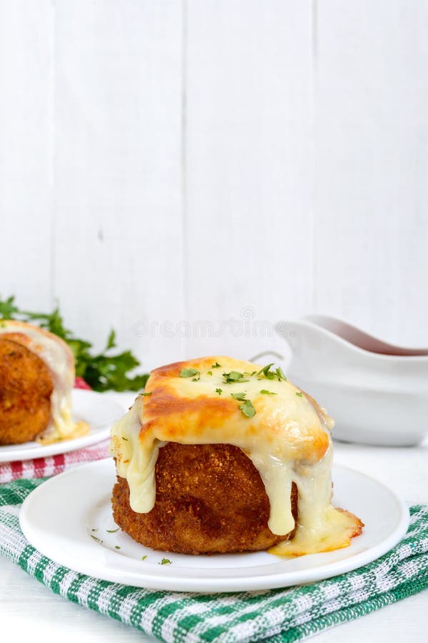 Potato balls with minced meat in deep fat, baked with mozzarella.