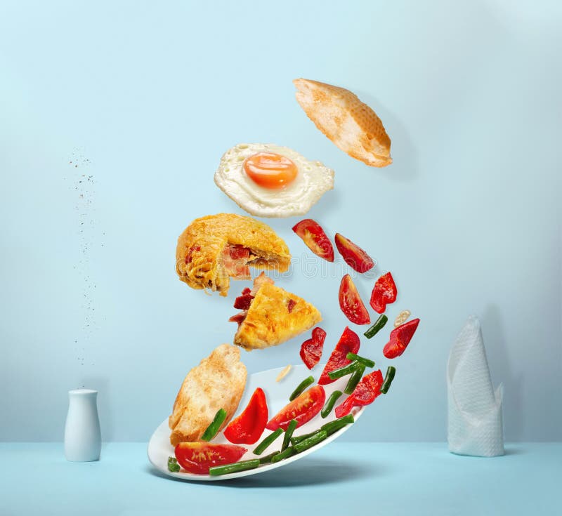 Potato pancake , salad, pieces of baguette and fried egg in levitation stock photo