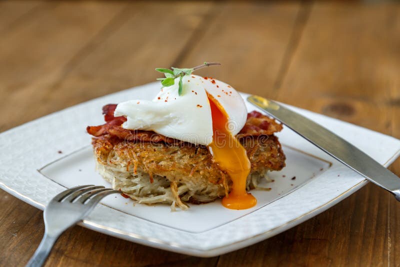 Potato Rosti, Poached Egg with Runy Yolk and Bacon on Top. Stock Image