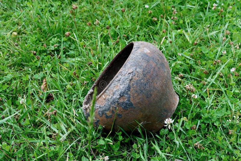 Pote sucio oxidado viejo del arrabio del vintage en hierba verde fotos de archivo Pote sucio oxidado viejo del arrabio del vintage en hierba verde fotos de archivo