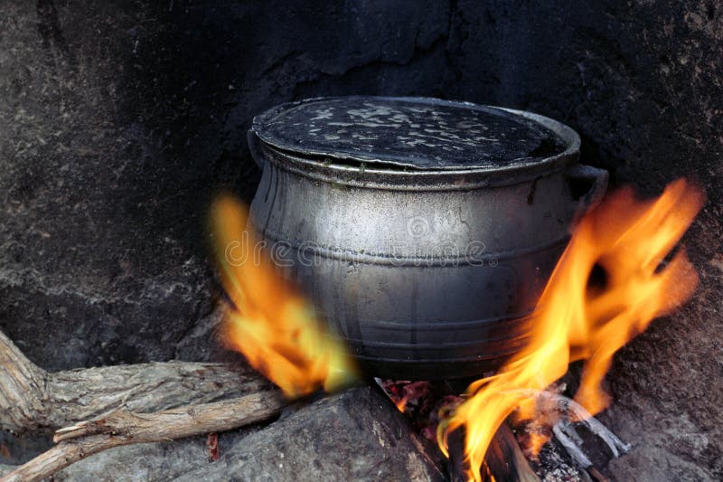 Potenciômetro coocking preto aquecido no incêndio fotografia de stock Potenciômetro coocking preto aquecido no incêndio fotografia de stock