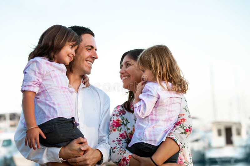 Close up family portrait of young couple holding their kids in arms outdoors. Close up family portrait of young couple holding their kids in arms outdoors.