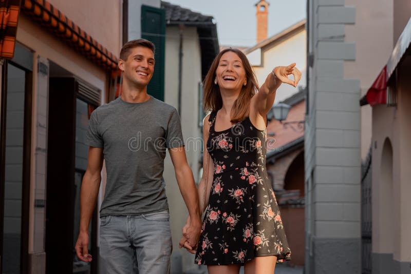 Potomstwa dobierają się w miłości patrzeje sklepowego okno w alei w ascona podczas zmierzchu obraz stock Potomstwa dobierają się w miłości patrzeje sklepowego okno w alei w ascona podczas zmierzchu obraz stock
