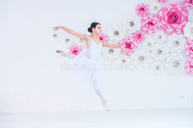 Potomstwa i niesamowicie piękna balerina są pozujący i tanczący w biały pracowniany pełnym światło fotografia stock Potomstwa i niesamowicie piękna balerina są pozujący i tanczący w biały pracowniany pełnym światło fotografia stock