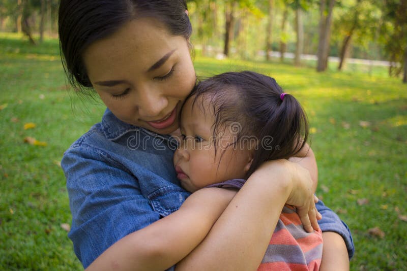 Young mother hugging and soothing a crying little daughter, Asian mother trying to comfort and calm down her crying child  High resolution image gallery. Young mother hugging and soothing a crying little daughter, Asian mother trying to comfort and calm down her crying child  High resolution image gallery