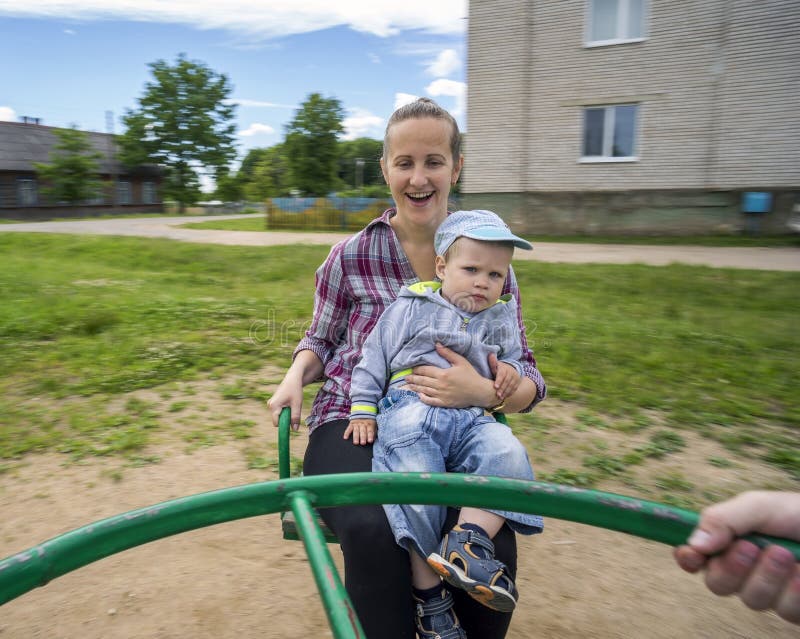 Potomstwa matkują z jej synem 1 3 roku jedzie na carousel fotografia stock
