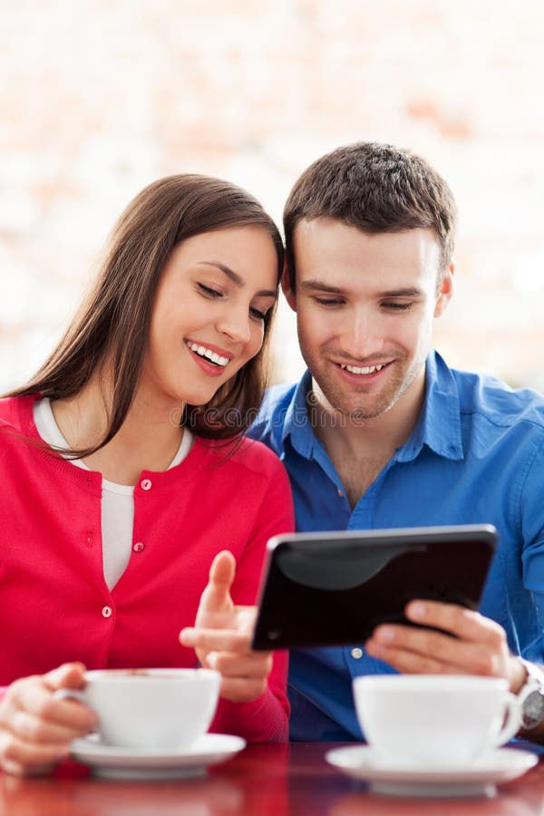 Young couple using digital tablet in cafe. Young couple using digital tablet in cafe