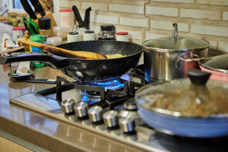 Pots with cooking food in the kitchen on gas stove stock images