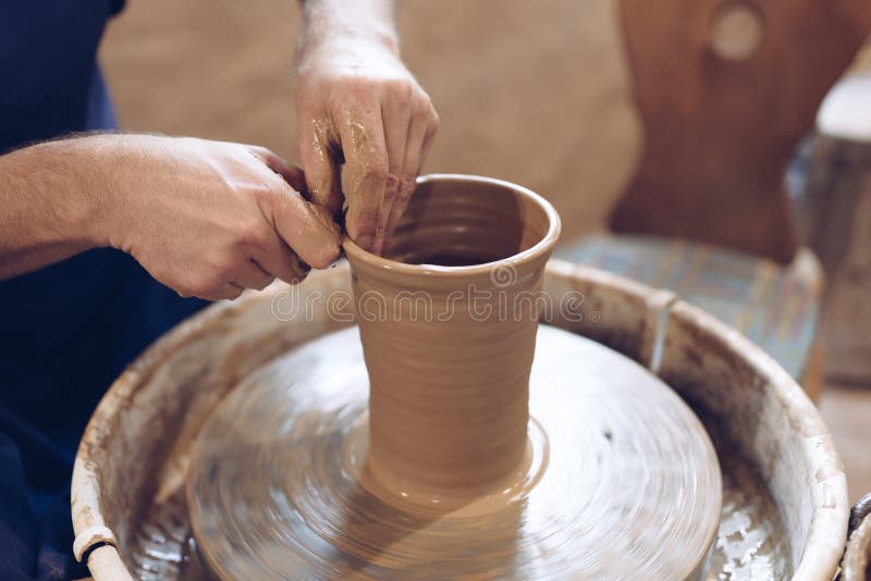 Potter making a clay vase on a potter`s wheel