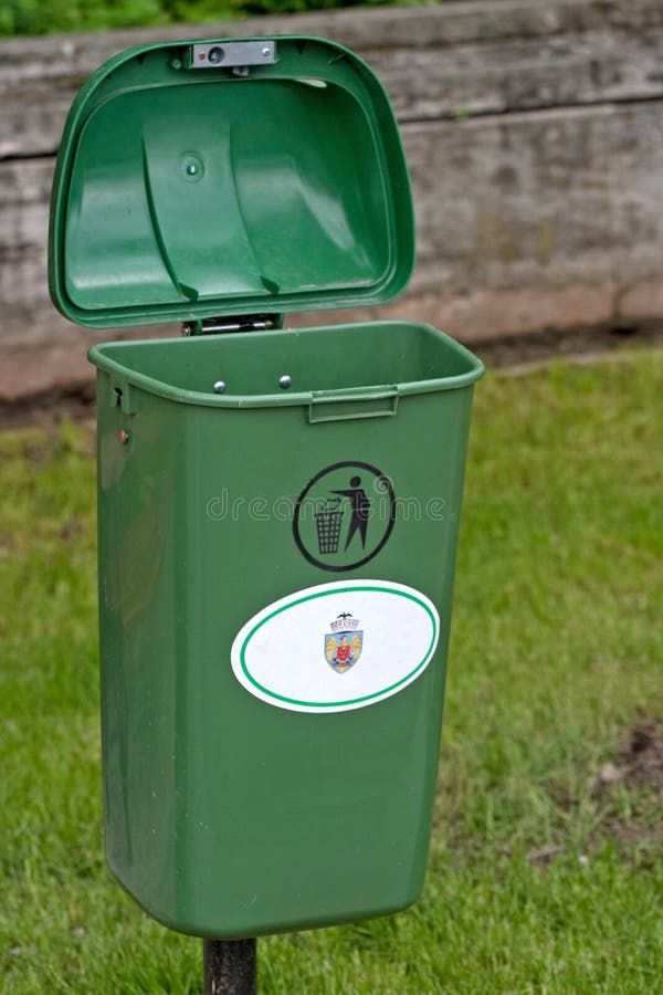 A trash can in a park. A trash can in a park.