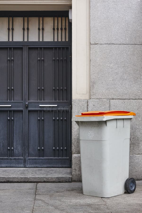 Garbage can on an urban building entrance door. Clean environment. Garbage can on an urban building entrance door. Clean environment