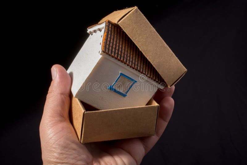 Pequena casa de modelo na mão numa caixa foto de stock royalty free