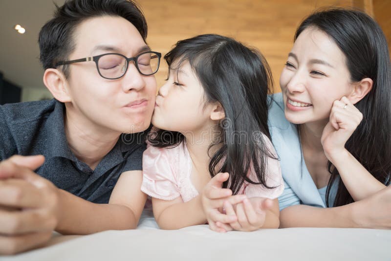 Pouco filha que beija pais em mordentes Retrato asi?tico da fam?lia imagens de stock Pouco filha que beija pais em mordentes Retrato asi?tico da fam?lia imagens de stock
