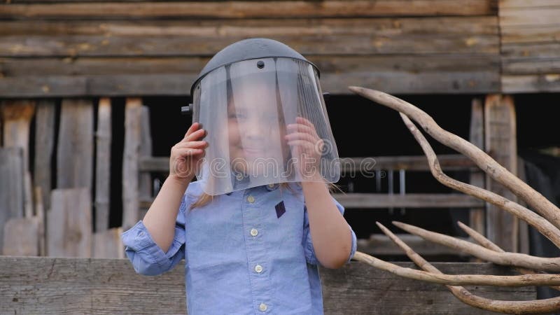 Pouco menina adorável cobre sua cara com uma máscara protetora