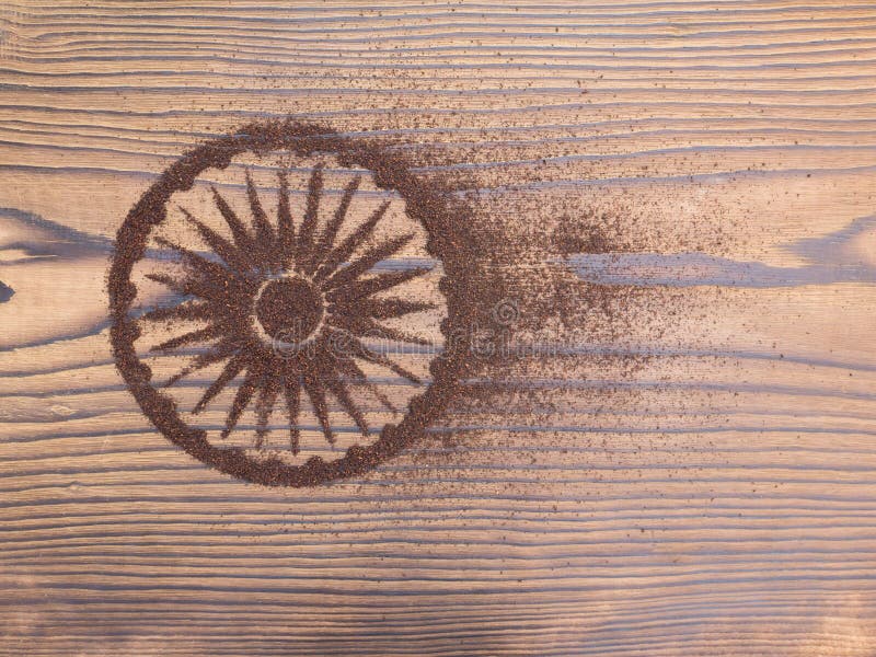 Indian tea powder in the form of Ashoka Chakra on the textured wooden board. Indian tea powder in the form of Ashoka Chakra on the textured wooden board