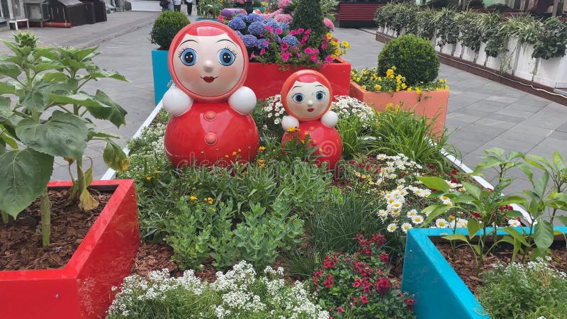 Poupées de nidification dans un jardin fleuri plein de couleurs et de verdure luxuriante banque de vidéos
