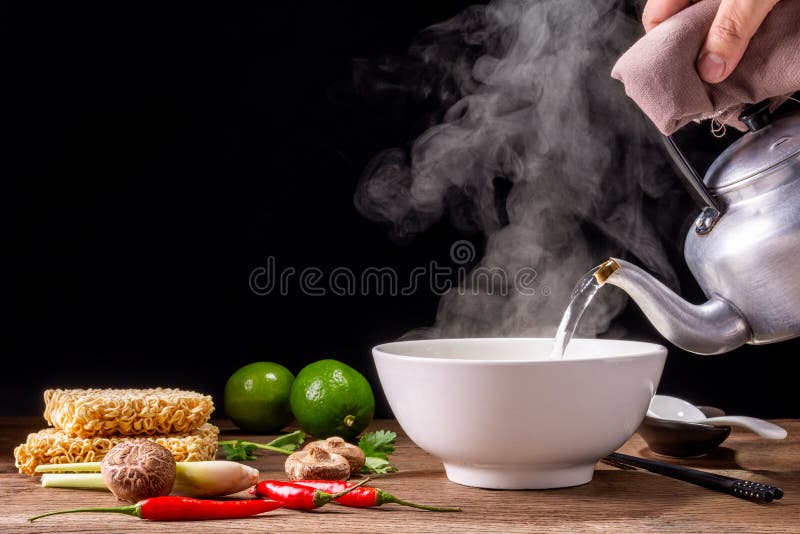 Pour hot water into a bowl of instant noodles or pasta. Delicious hot soup Thai Chinese, Japanese condiments, lemon chili shitake