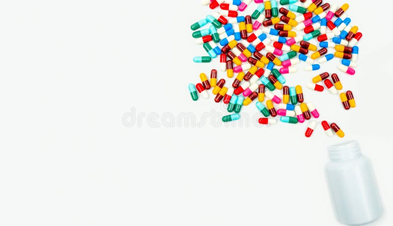 Pouring antibiotics capsule pills into plastic bottle isolated on white background with copy space. Drug resistance concept. Antibiotics drug use with reasonable and global healthcare concept.