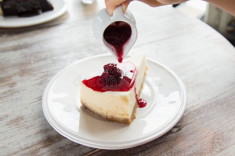 Pouring Blueberry Sauce Topping on Cheese Cake. Stock Image Image of