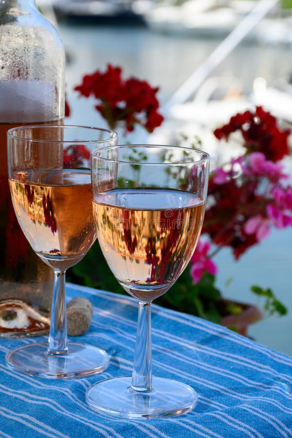 Wine and cake of French Riviera, glasses of cold rose Cote de Provence wine and Tarte Tropezienne cake in yacht harbour of Port stock images