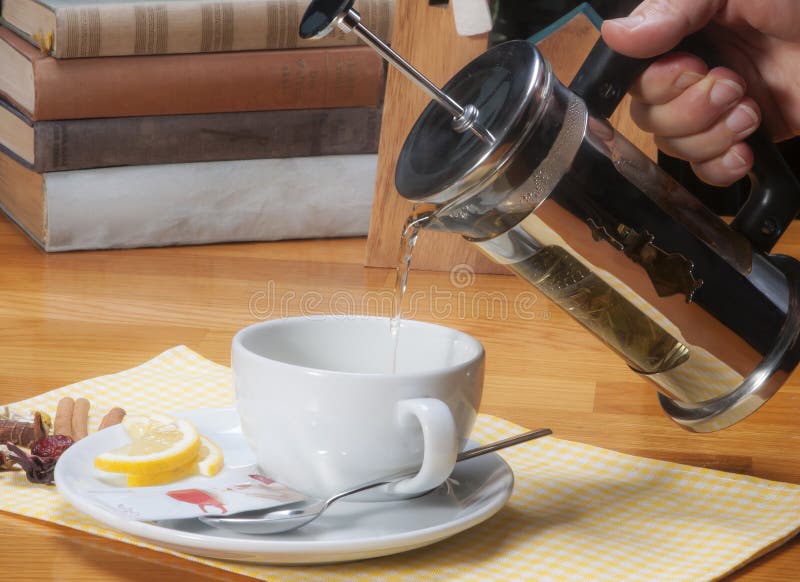 Pouring Herbal Tea with French Press Teapot into White Cup Stock Image