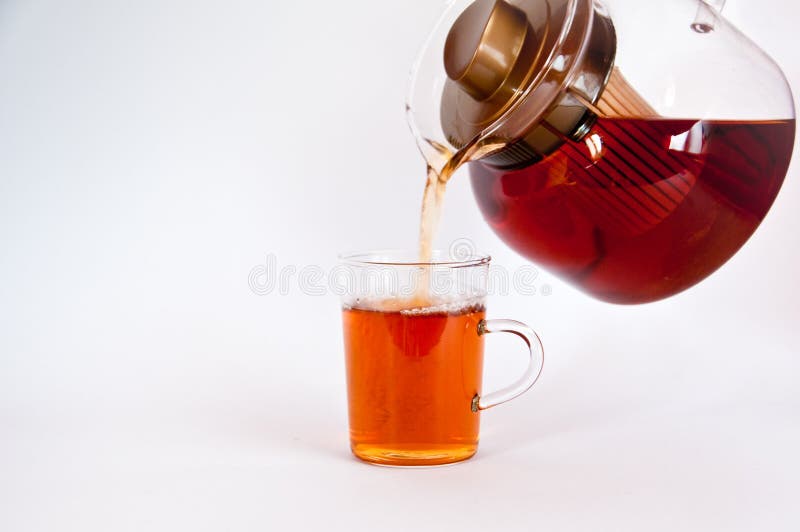 Pouring hot black tea into glass