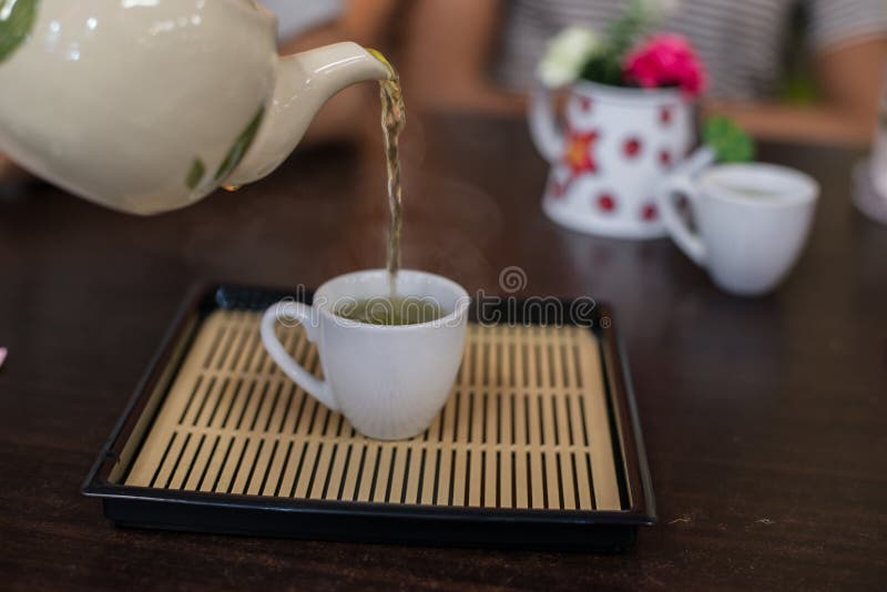 Pouring Hot Green Tea To Cup. Stock Photo Image of white, drink
