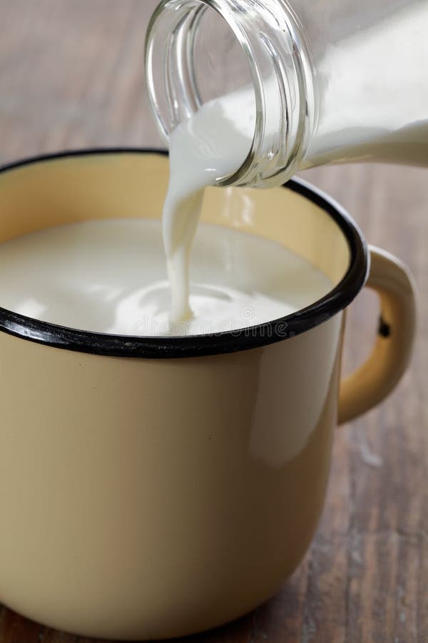 Pouring Milk Into Cup With Tea Stock Photo - Image of napkin, blue