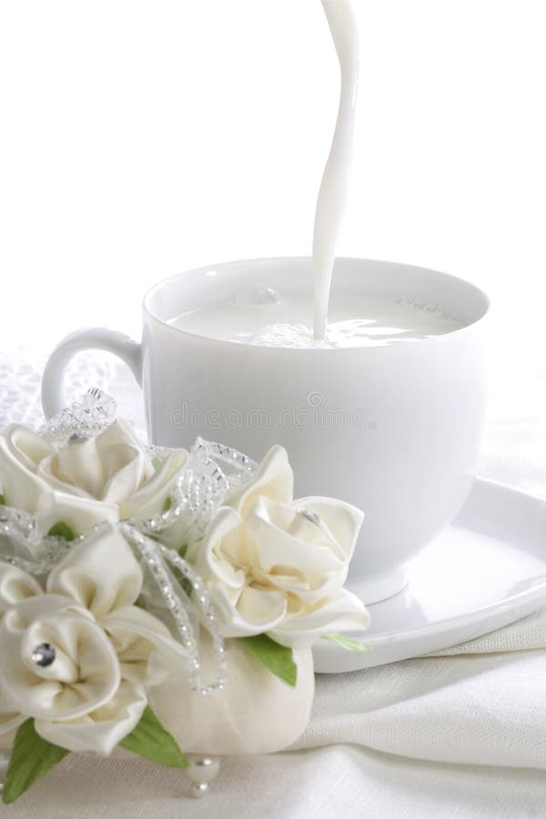 Devanado fundición blanco taza próximo sobre el de seda rosas en blanco Manteles.