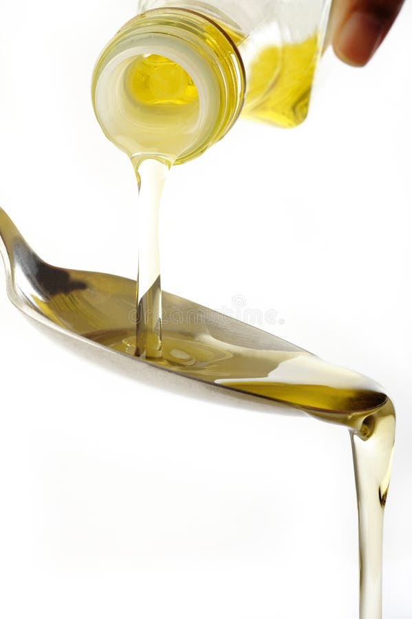 Pouring oil at on spoon stock image. Image of yellow 53027747